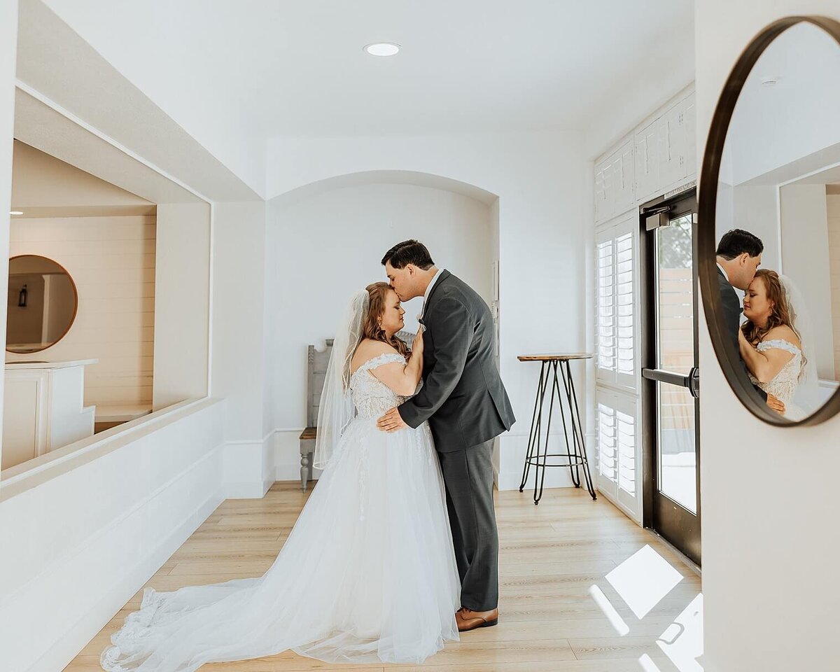 bride and groom portrait with groom kissing the bride on her forhead. Photo by Michelle Betz Photography