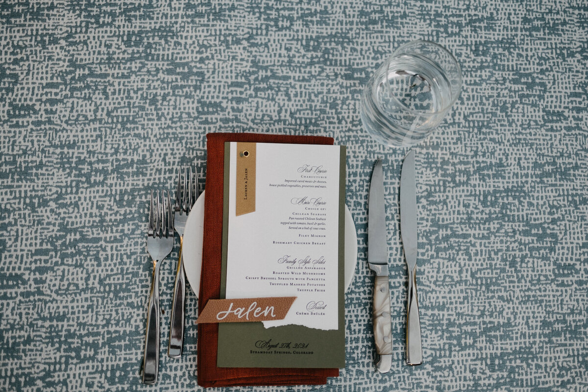 Dark green and terracotta place settings with leather place card