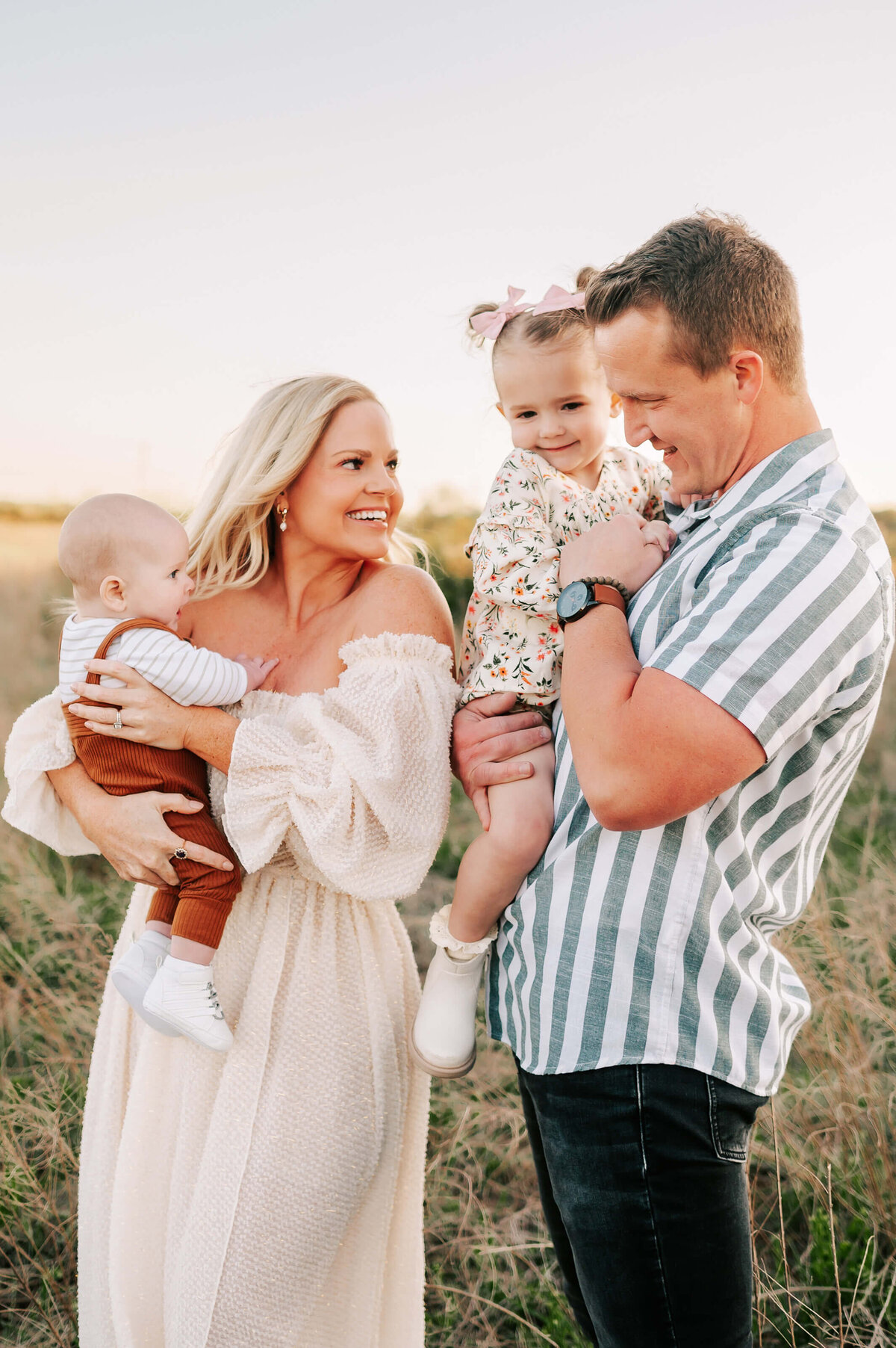 family laughing together at sunset in a field during Springfield MO family photography session