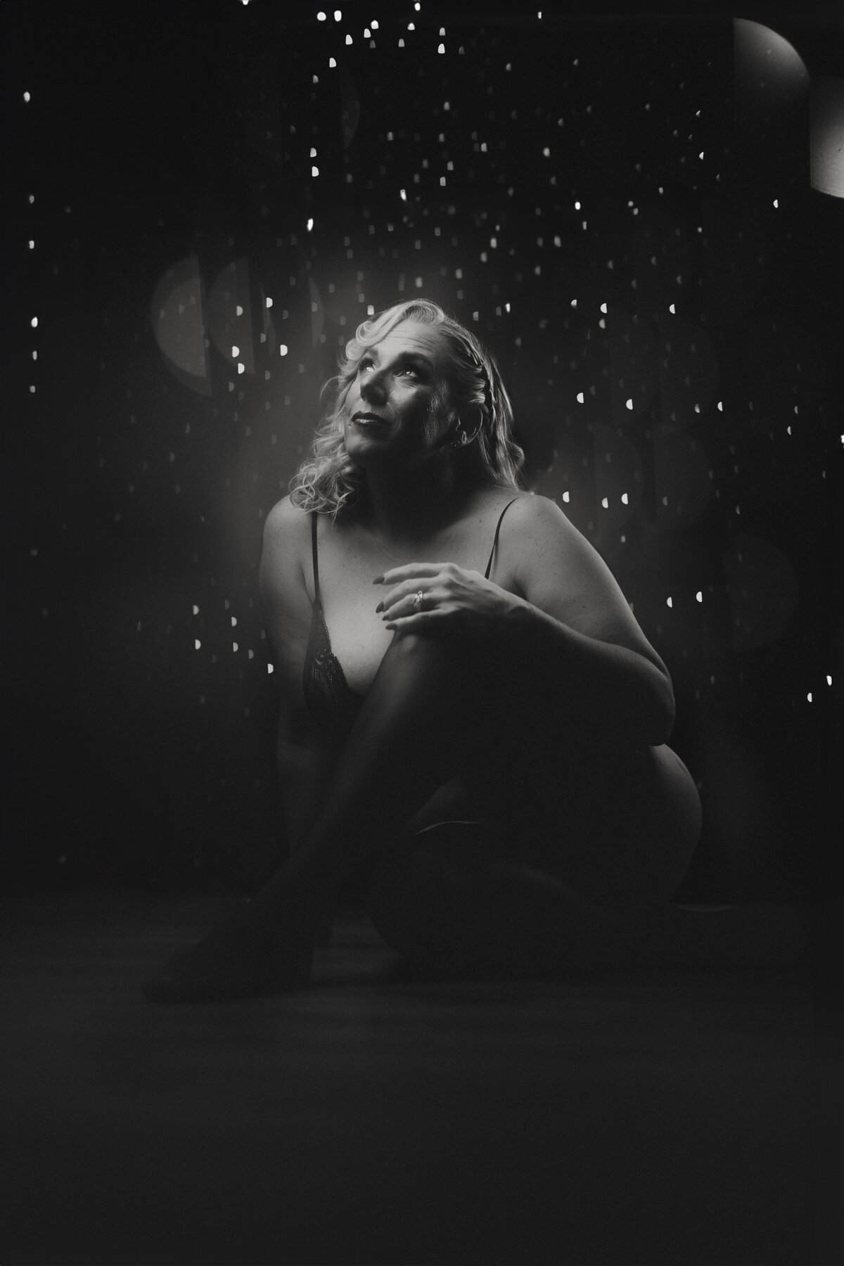 Black and white boudoir image with dramatic shadows and starlike lights—ideal for empowering women in Florida’s boldest shoots.