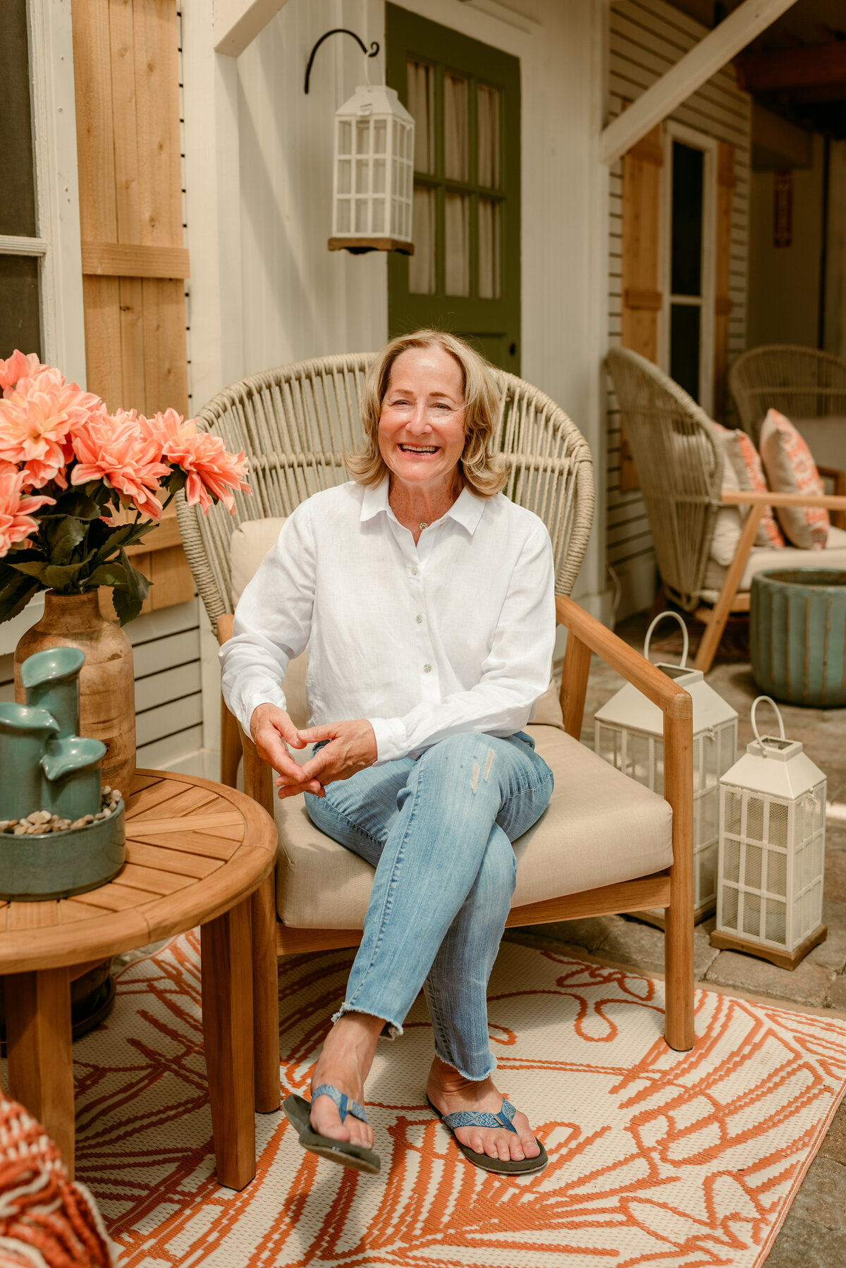 Elegant woman in a white blouse seated in a cozy cafe corner with flowers, creating a warm and friendly dating profile image.