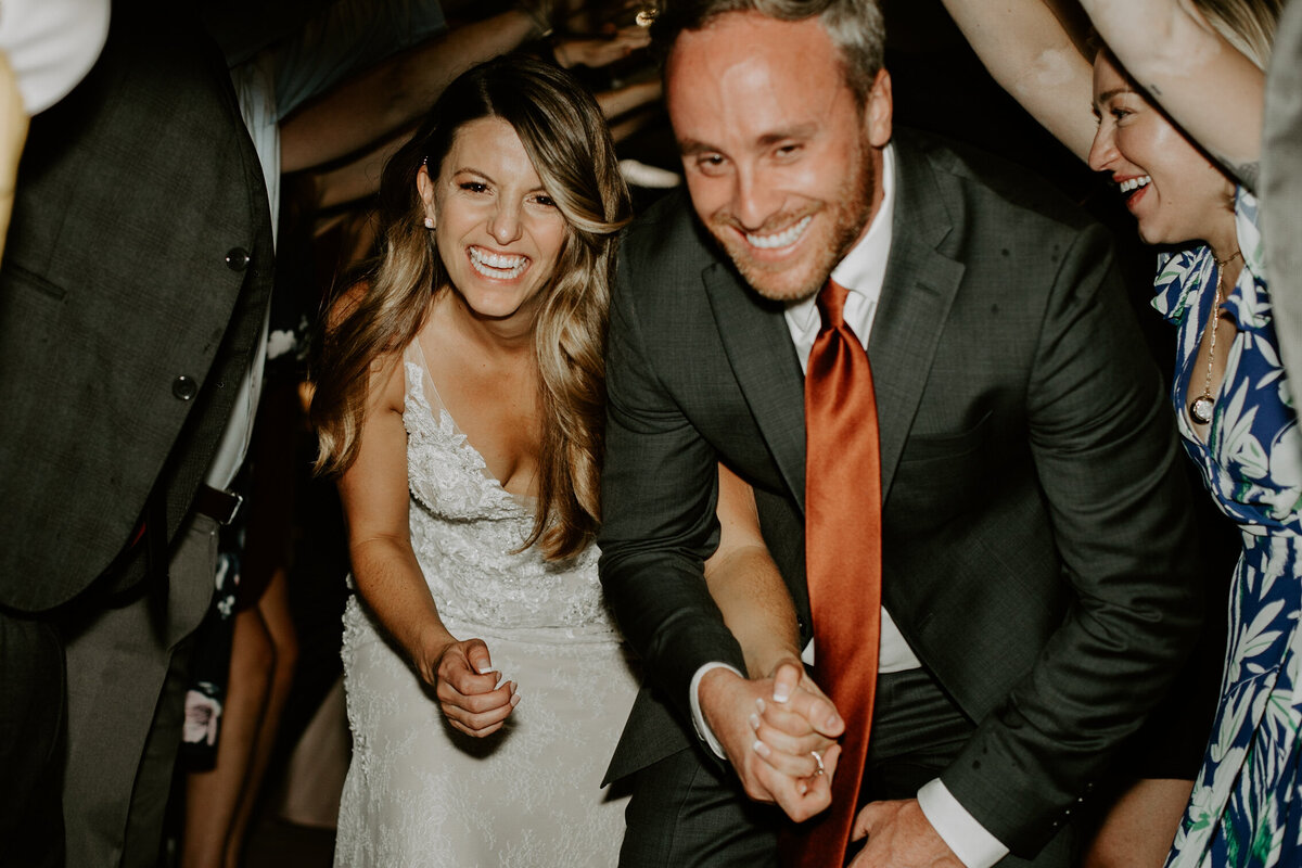 Bride and groom go through a tunnel of their guests on their wedding reception.