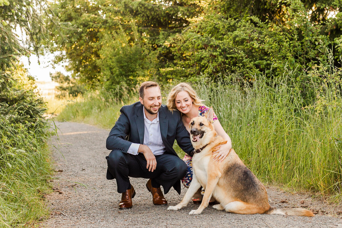 PNW engagement session at Discovery Park Seattle happy couple smiling and laughing with dog colorful fun candid photo by Joanna Monger Photography