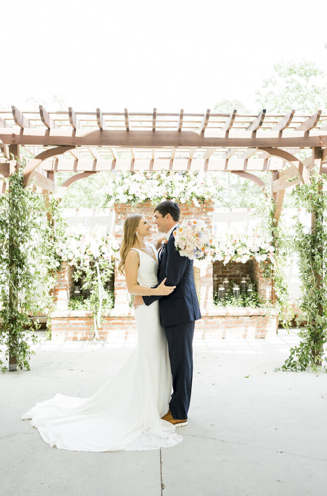bride and groom portrait in front of fireplace decorated with florals