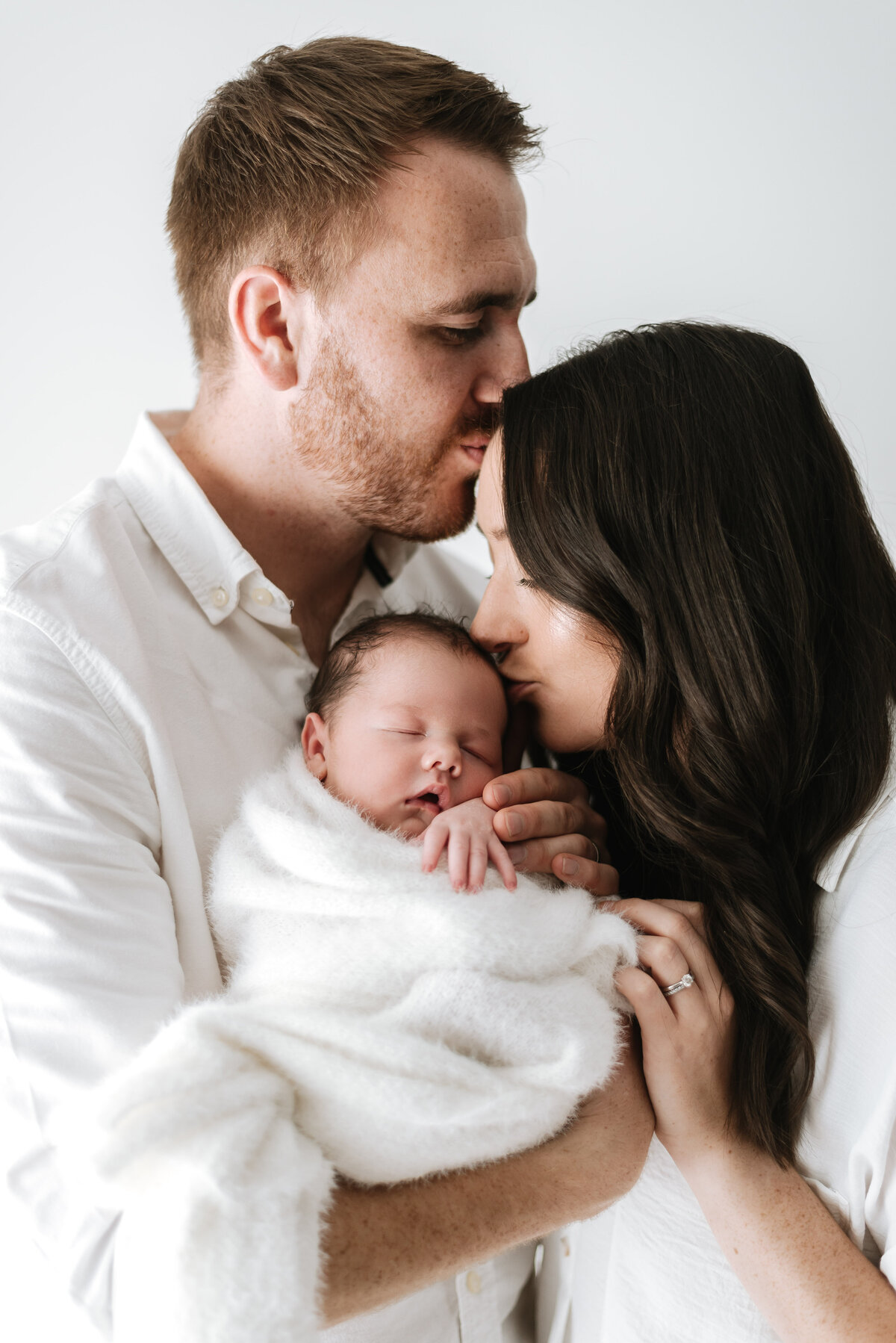 Mother and father holding newborn baby at newborn photoshoot in Billingshurst
