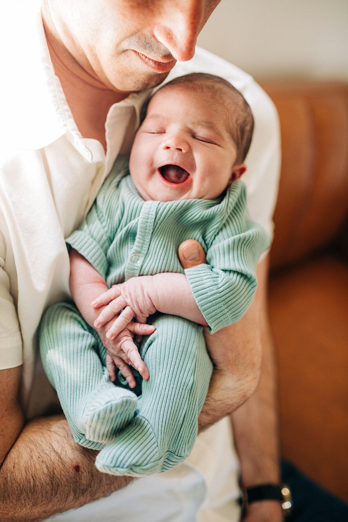 smiling newborn held by dad