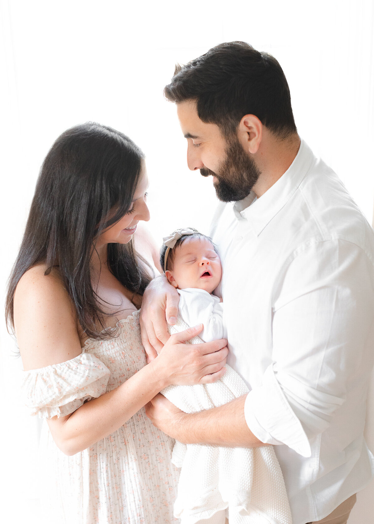 new parents hold their sleeping newborn during boston baby photo session