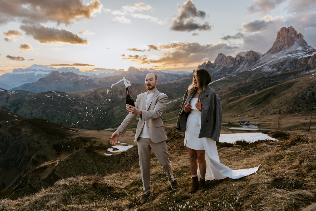 romantic couple drinking wine during twilight elopement in Dolomites