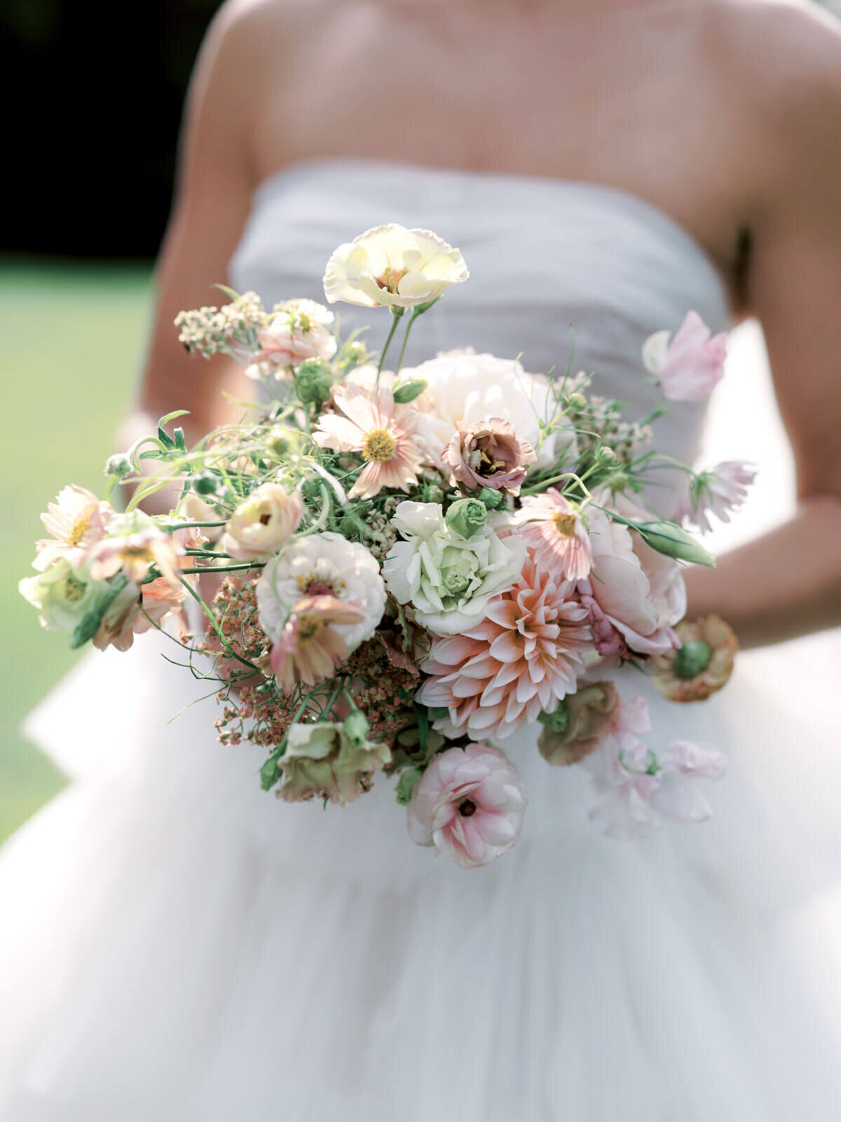 Close-up shot of the bride's peach and white flower bouquet, held by the bride at The Ausable Club, NY. Images by Jenny Fu Studio