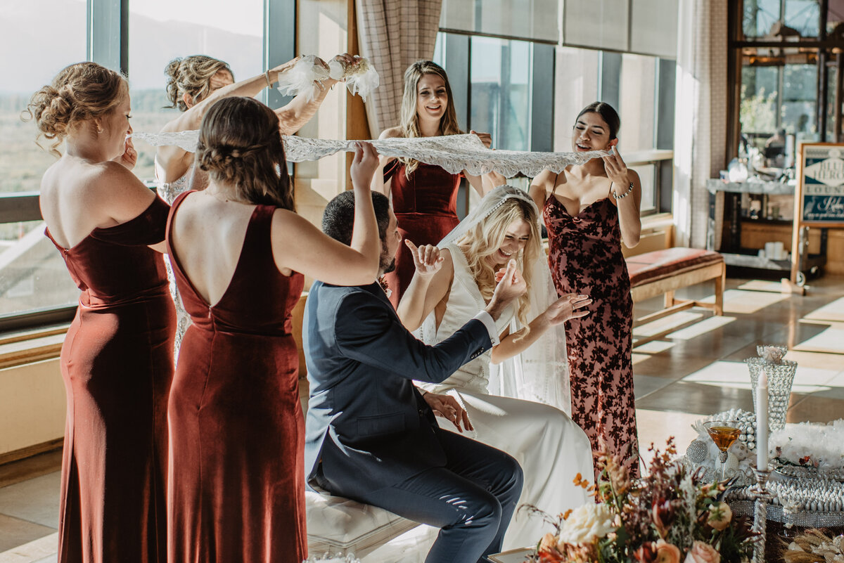 Photographers Jackson Hole capture bride and groom sitting under table cloth