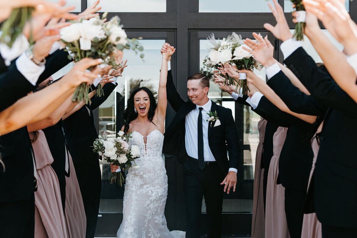 Bride and groom surrounded by bridal party tunnel planned by chicago wedding planners