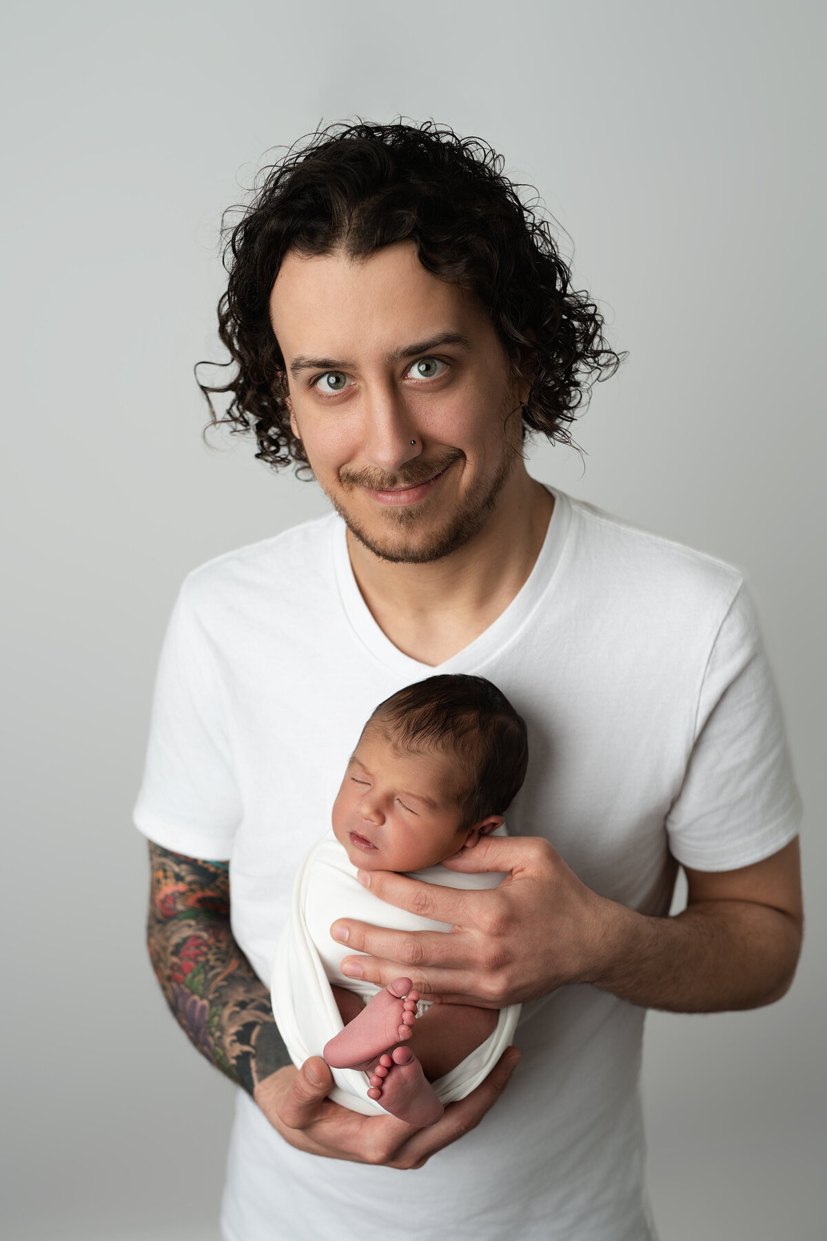 Newborn studio portrait of father holding baby boy | Paris Ontario family photography by Meraki Photographic Creations