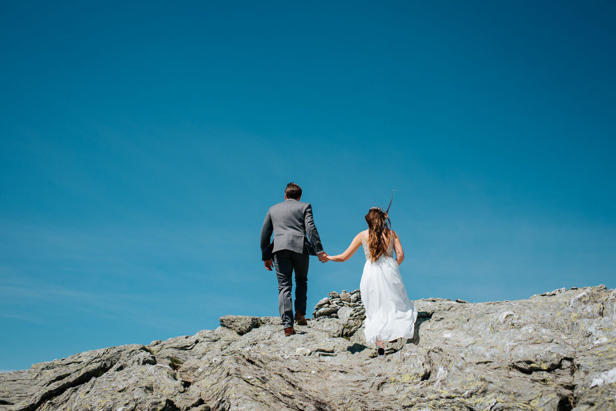 couple walking up rocks at mount mansfield elopement in stowe vermont adventure