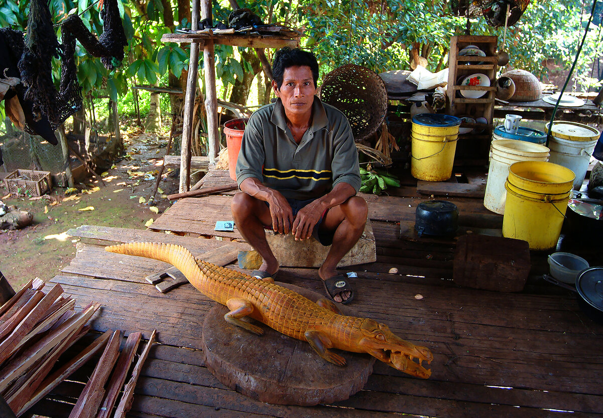 This village carver fashions  a crocodile from  a rare wood known locally as cocobolo