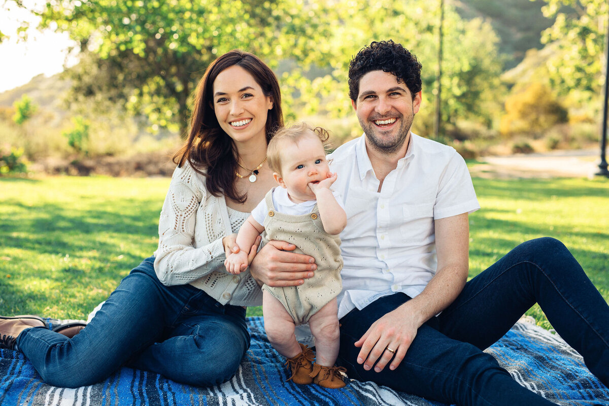 Family Portrait Photo Of Couple Smiling While Holding Their Baby In Los Angeles