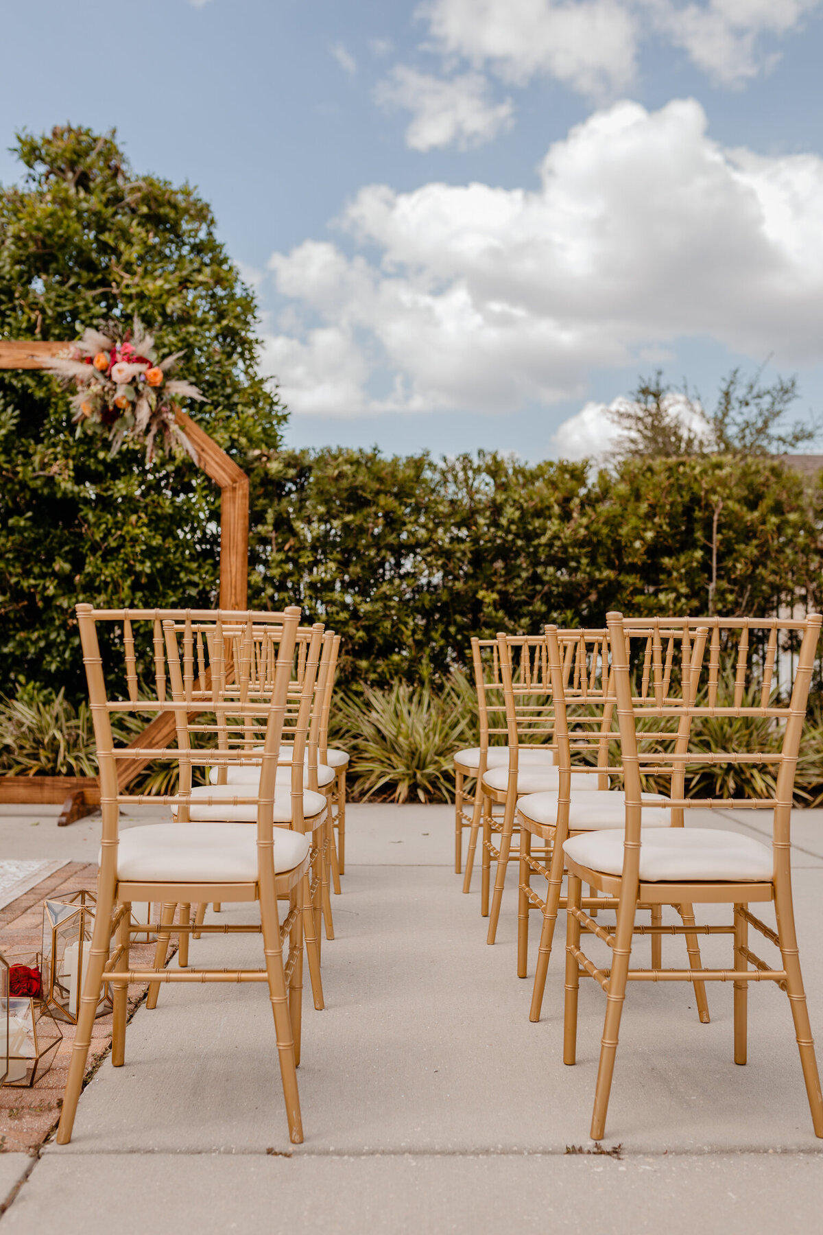 alt="gold chairs at wedding ceremony"