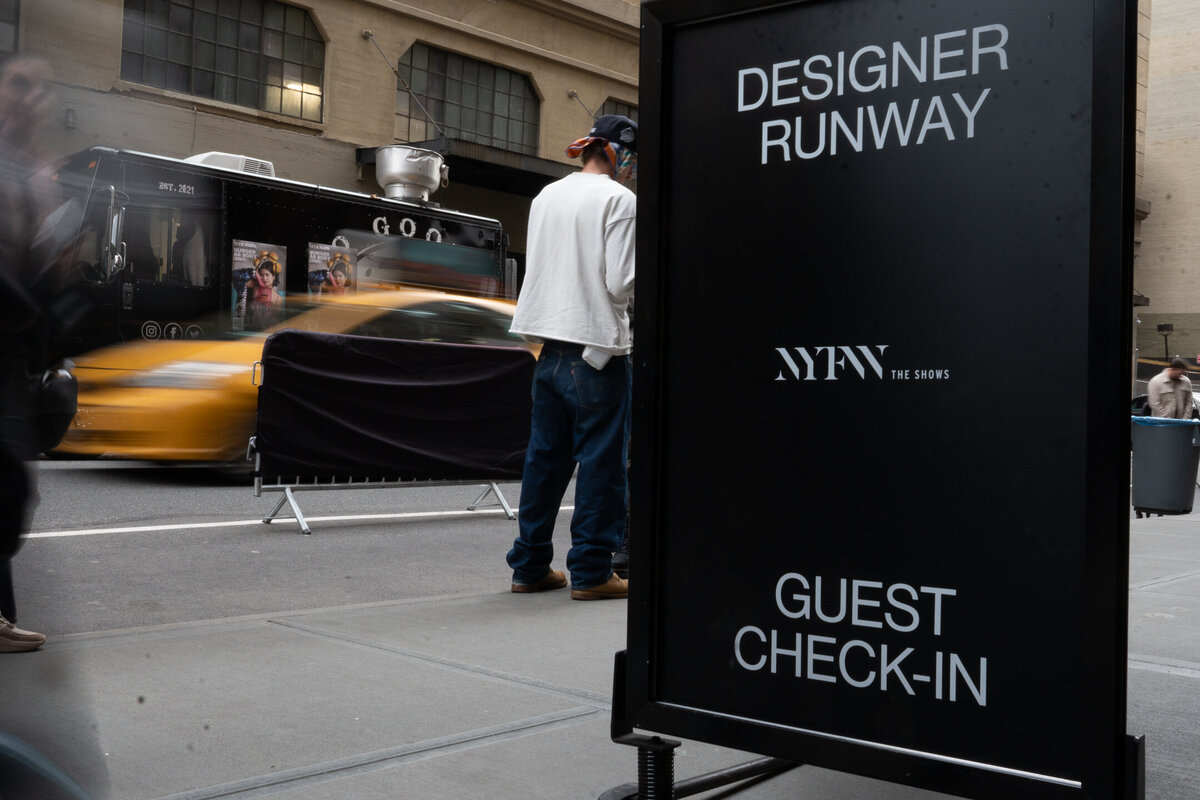 nyfw sign with taxi in background