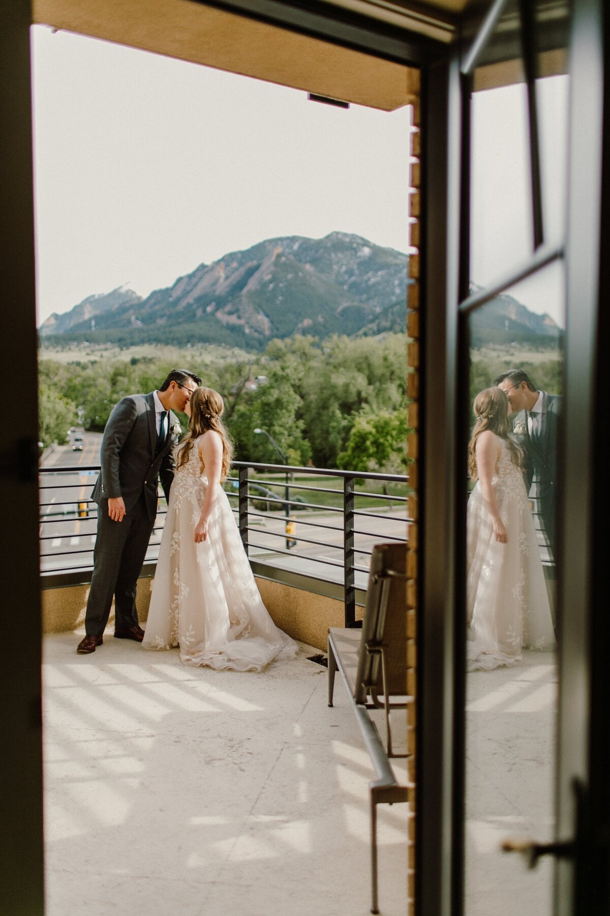 Bride and groom share a kiss in front of mountain views on their wedding day in Boulder Colorado.