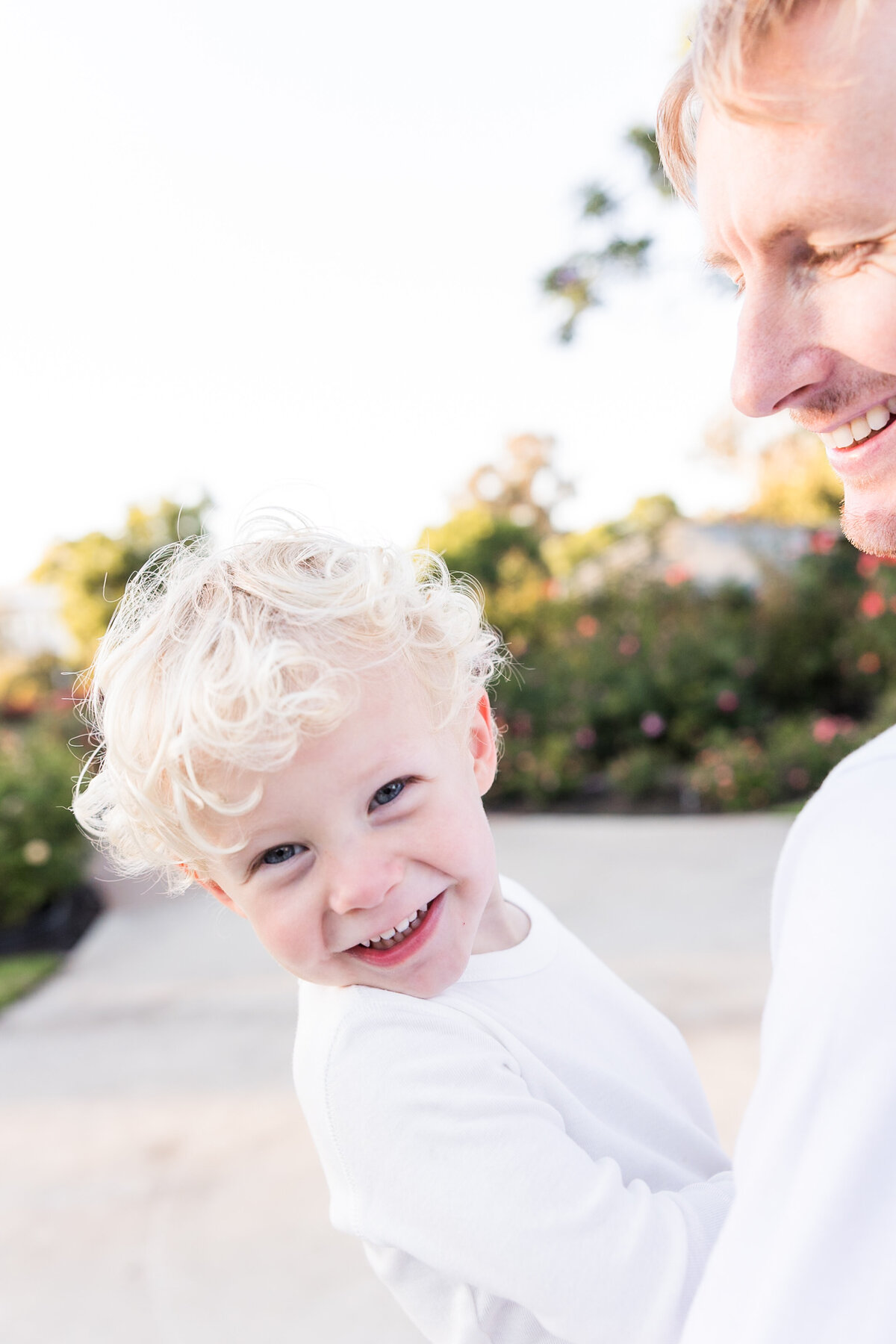young boy laughing in fathers arms