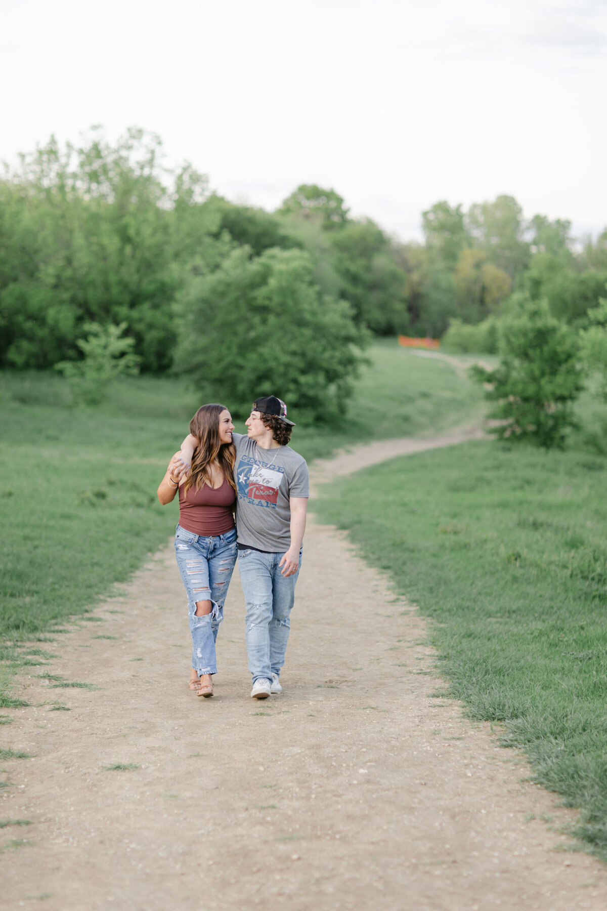 happy couple walking trail during engagement session