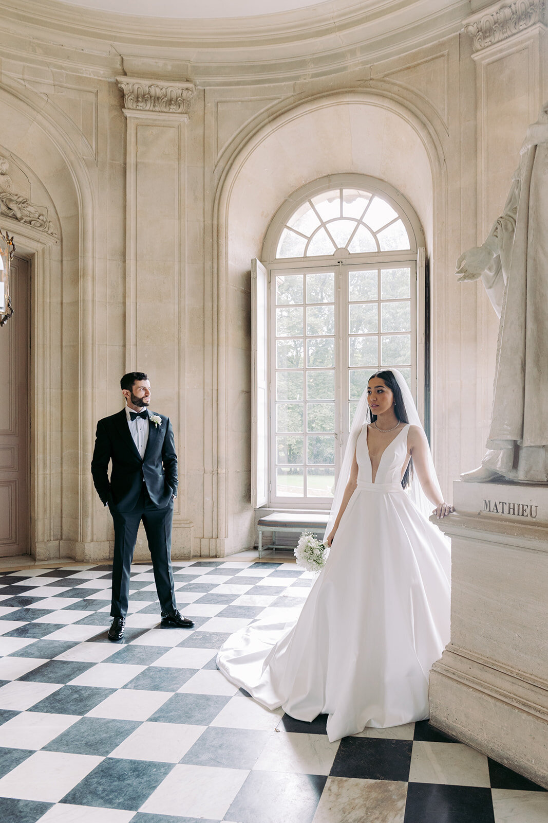 Groom watching the bride getting in the Chateau de Champlatreux