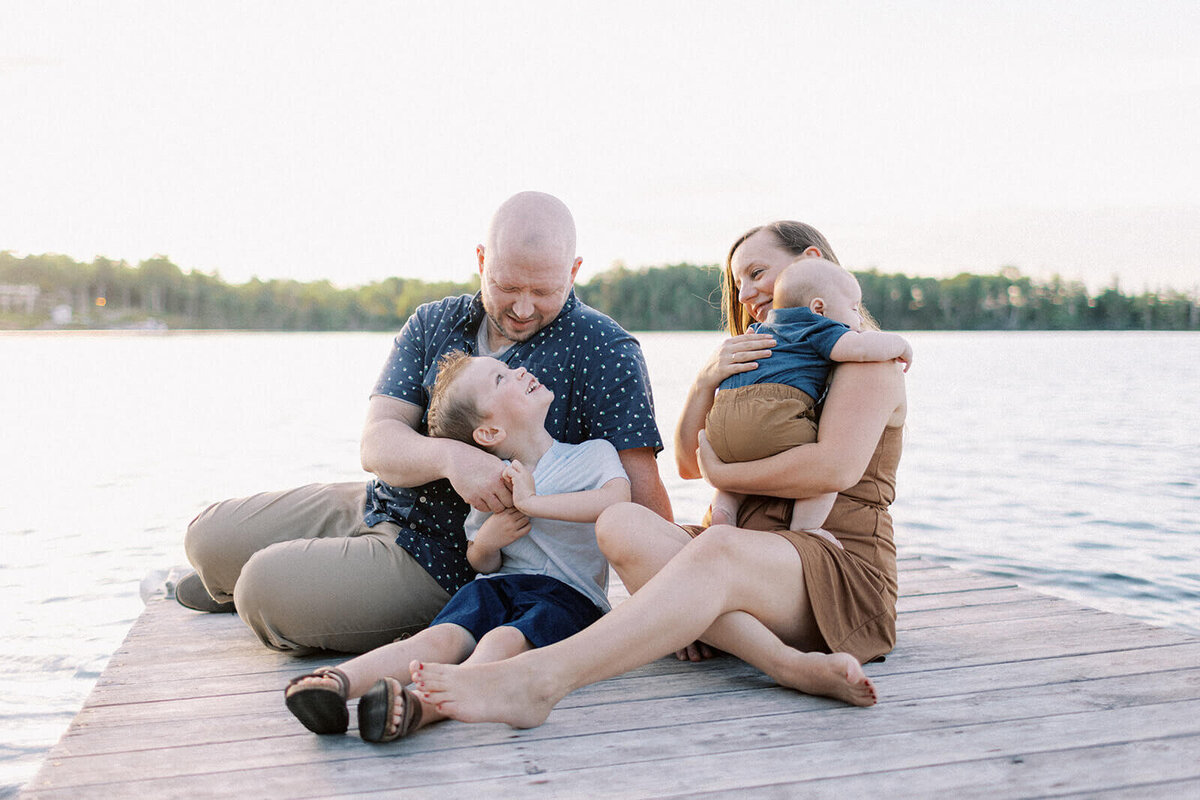 family-sit-on-dock-by-the-sea