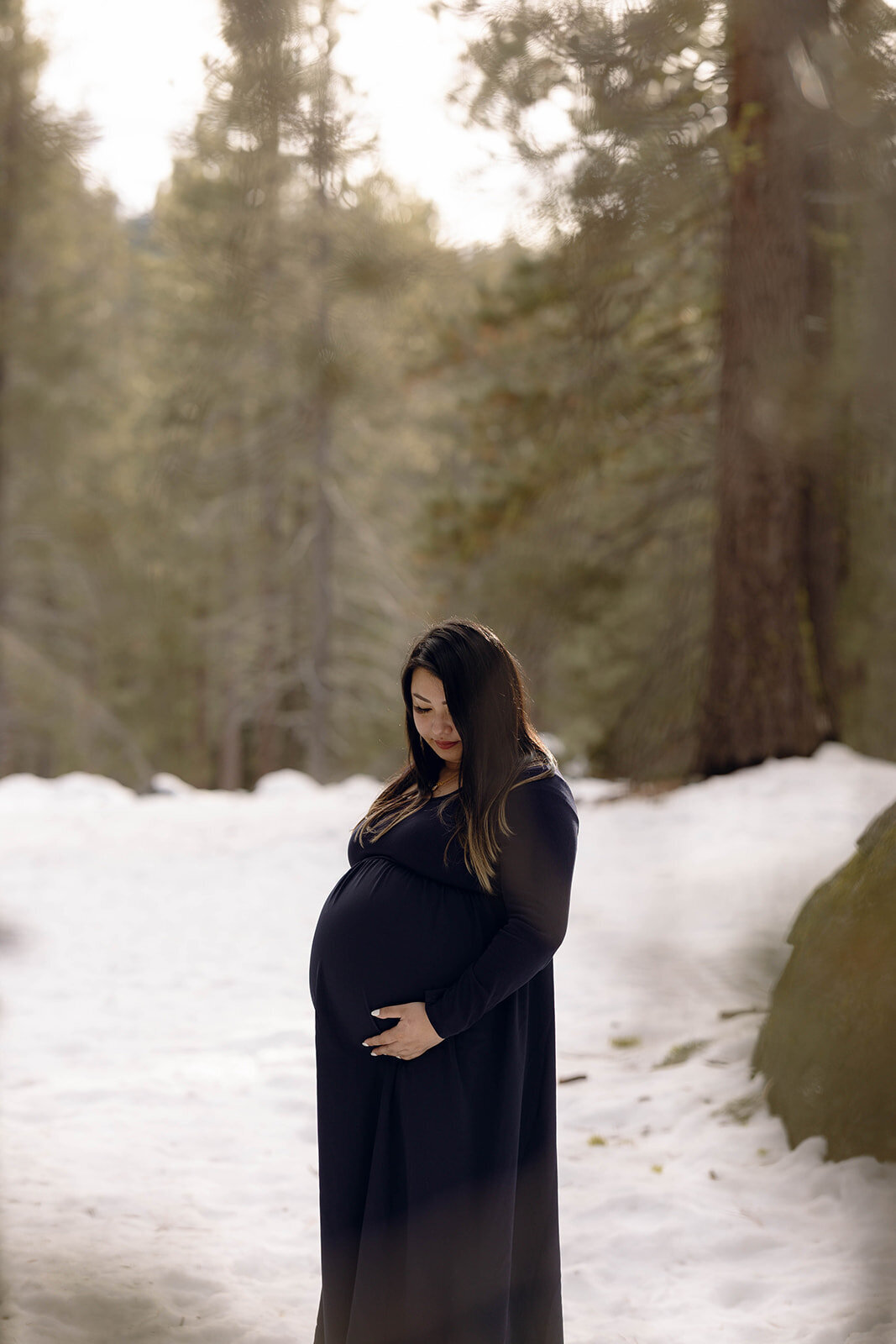 A serene maternity portrait in a snow-covered landscape, blending fine art and documentary wedding photography.