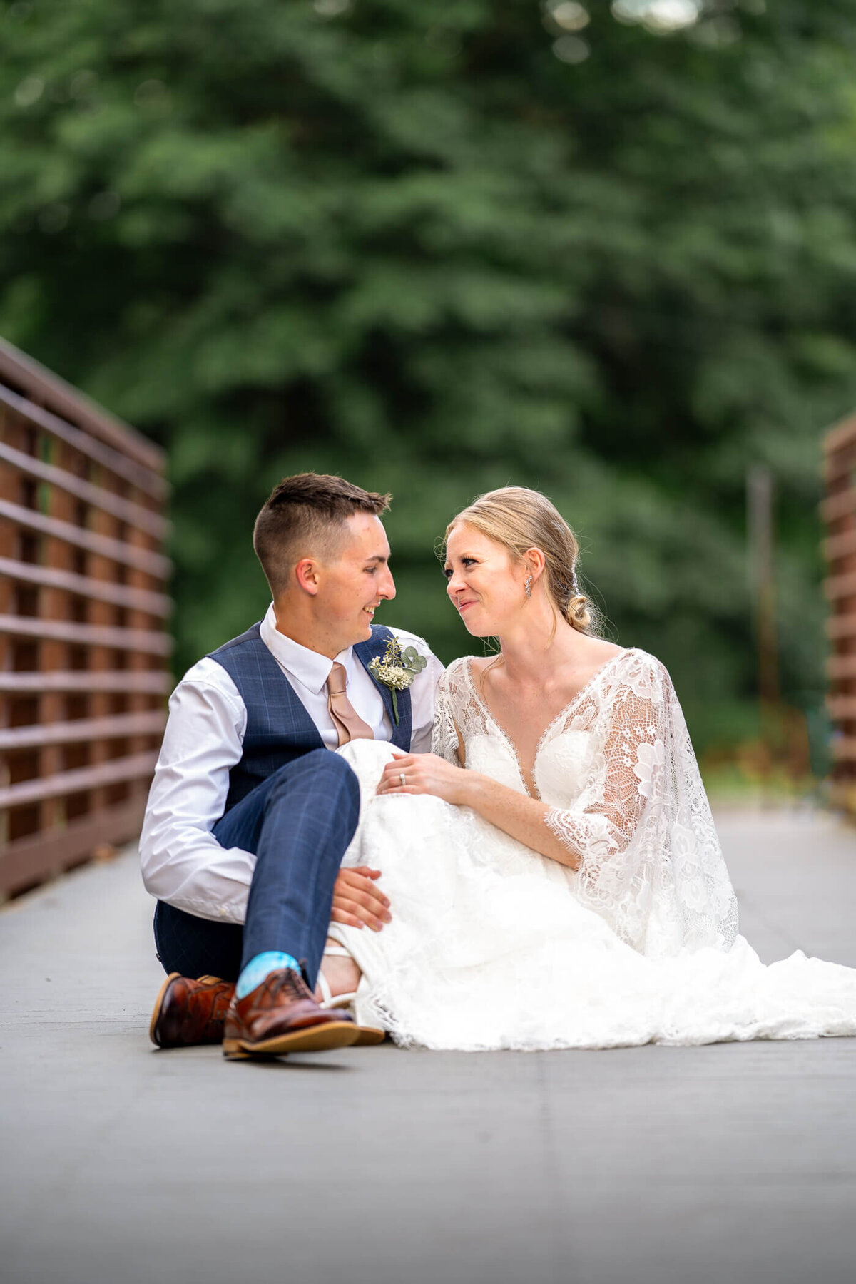 bride and groom sit together and try to make each other laugh on a bridge wedding reception, captured by Pittsburgh Wedding photographer Michael Fricke Photography