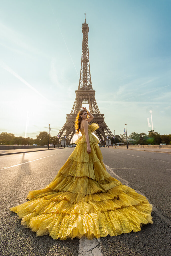 Princess portrait session at Iena Bridge Paris featuring woman in golden ball gown and crown with centered Eiffel Tower
