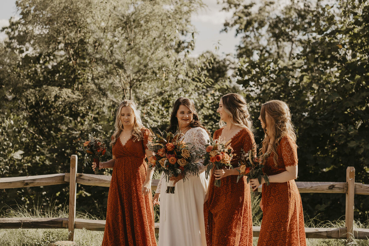 Bride walking with her bridesmaids who are in orange dresses