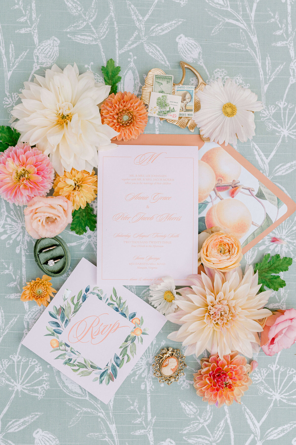 Wedding photography flatlay of peach and green invitation suite.