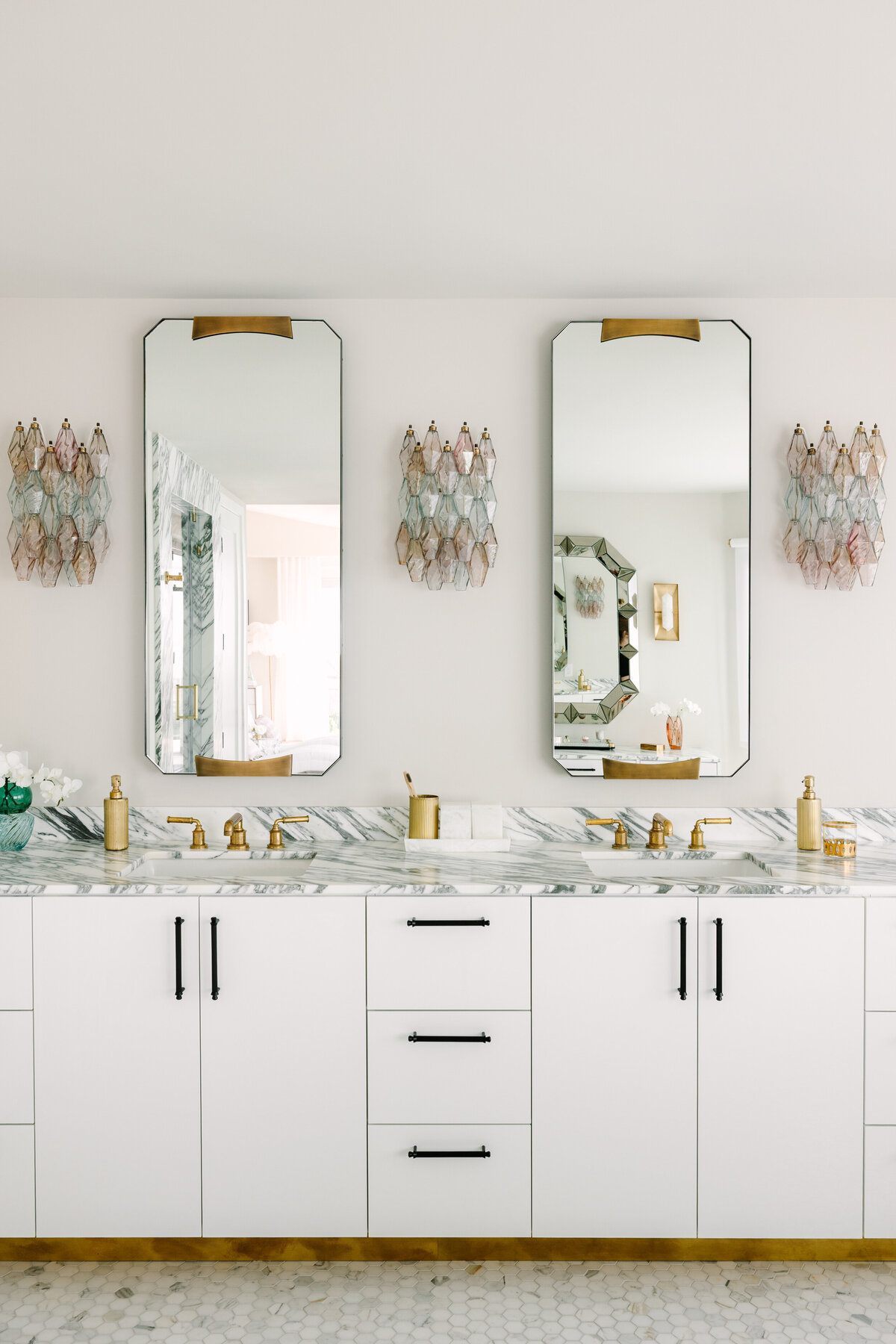 Primary bathroom with white high gloss vanity and brass base, Arabescato Corchia marble counters, and vintage Carlo Scarpa Venini sconces.