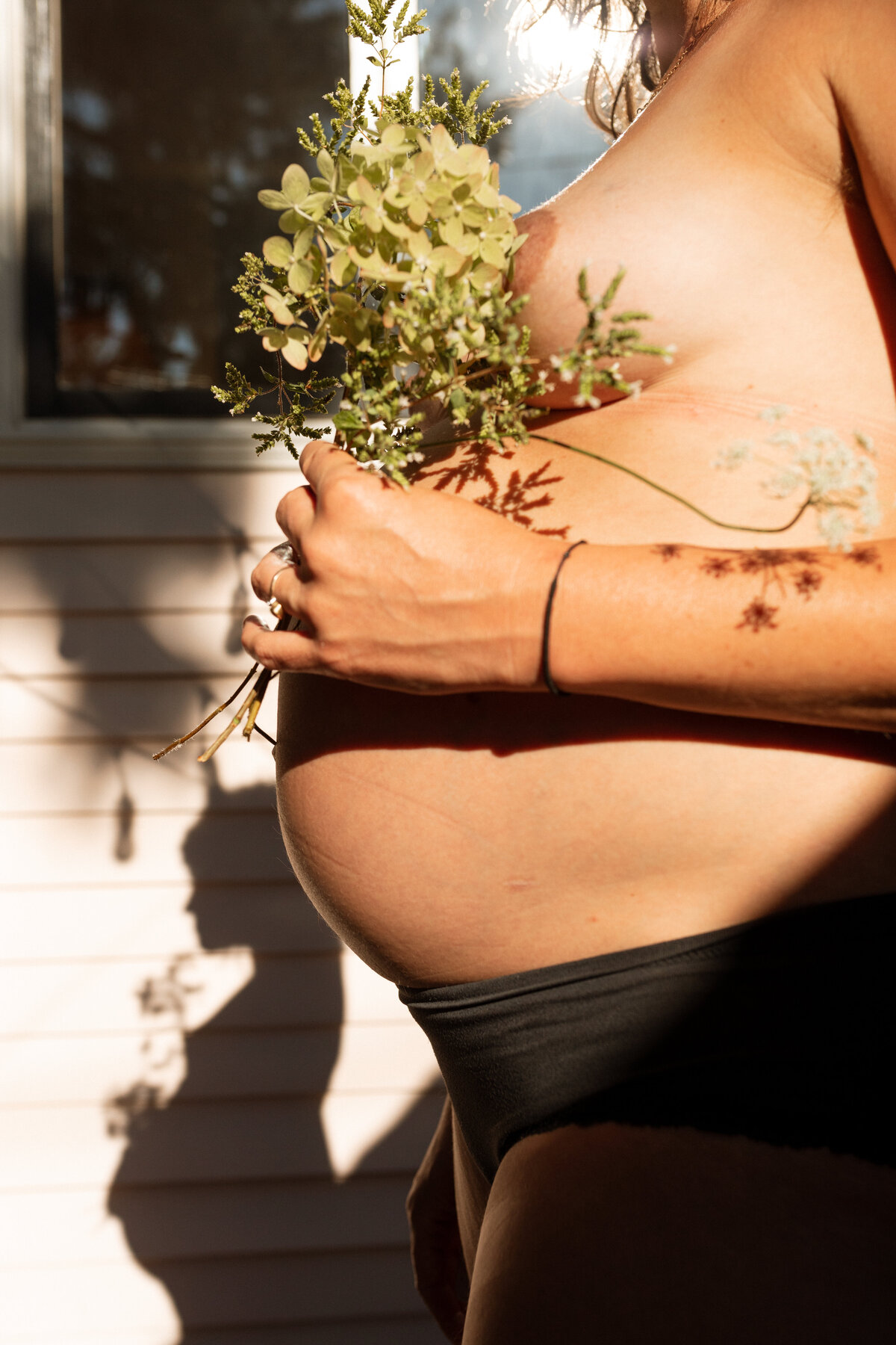 Expecting Mother Holds Flowers By Tummy