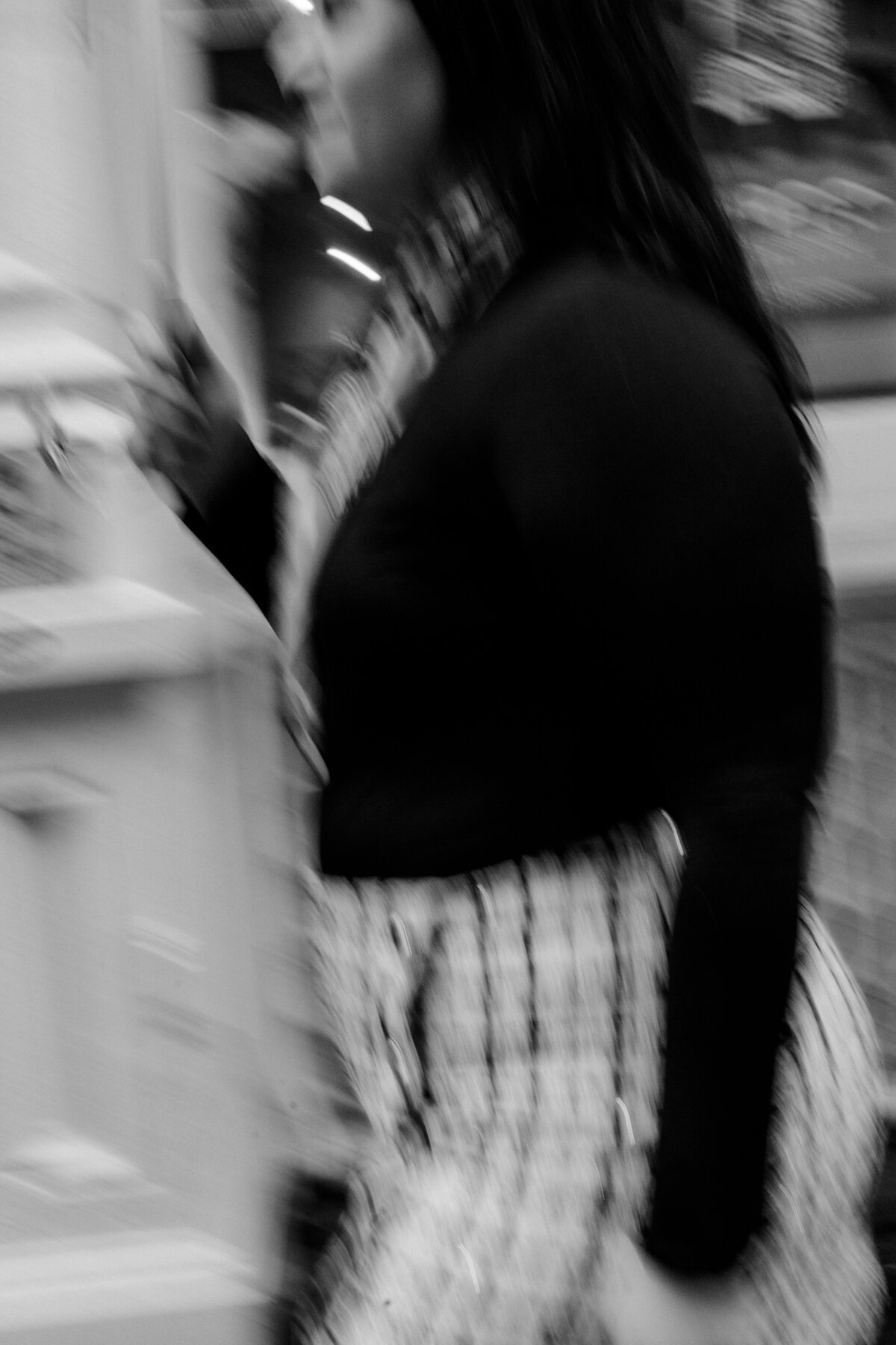 blurry black and white image of a woman walking