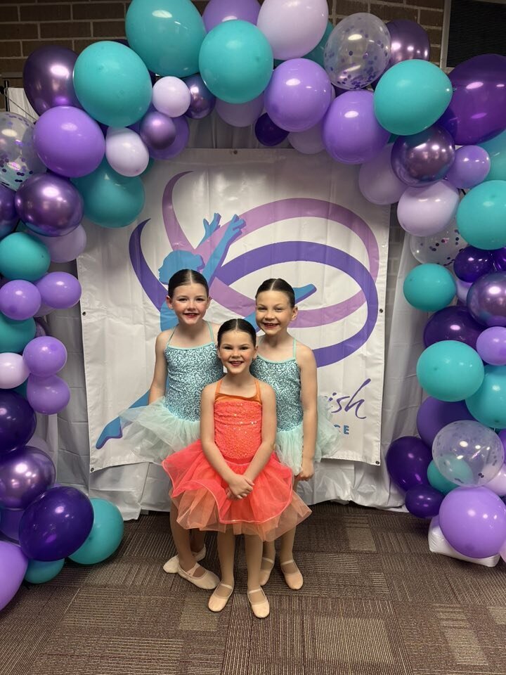 3 little ones in costume with the patti parrish dance background at recital