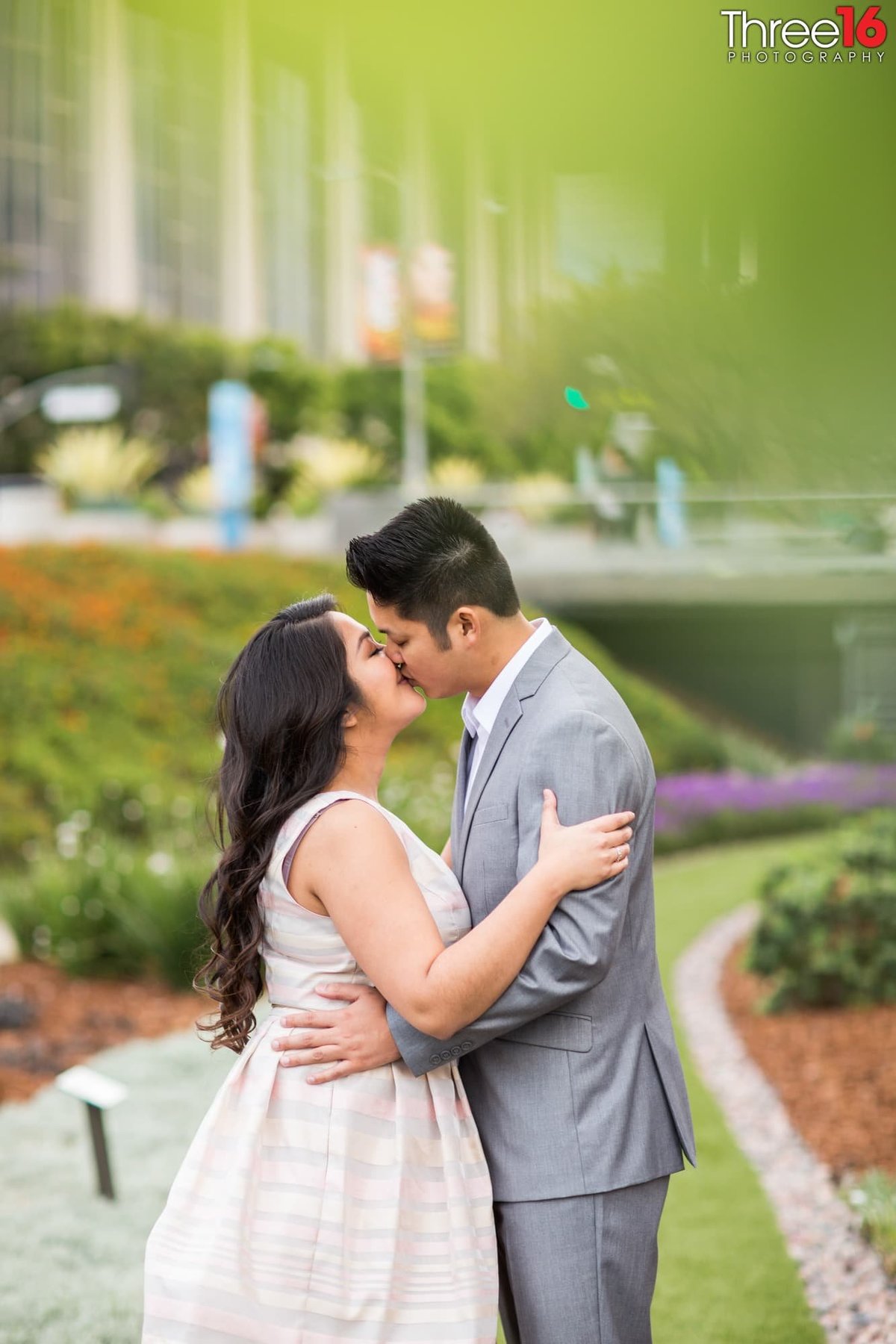 Engaged couple kiss on the grounds of the Los Angeles Department of Water & Power