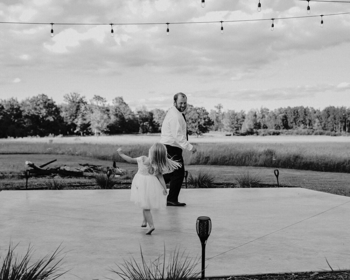 black and white photo of man and little girl dancing