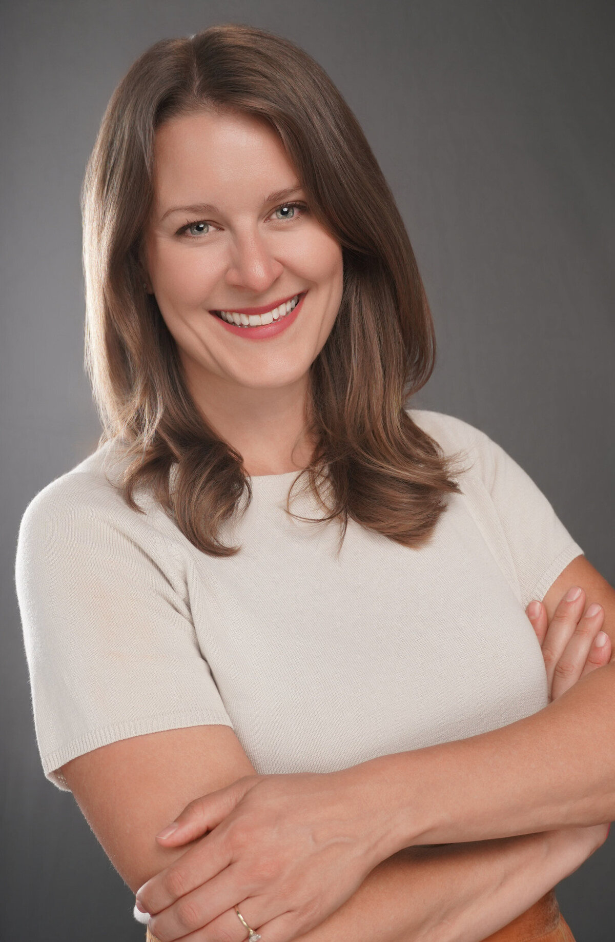 Confident business headshot of a smiling woman with arms crossed, photographed in Atlanta by Lynda Louis Photography