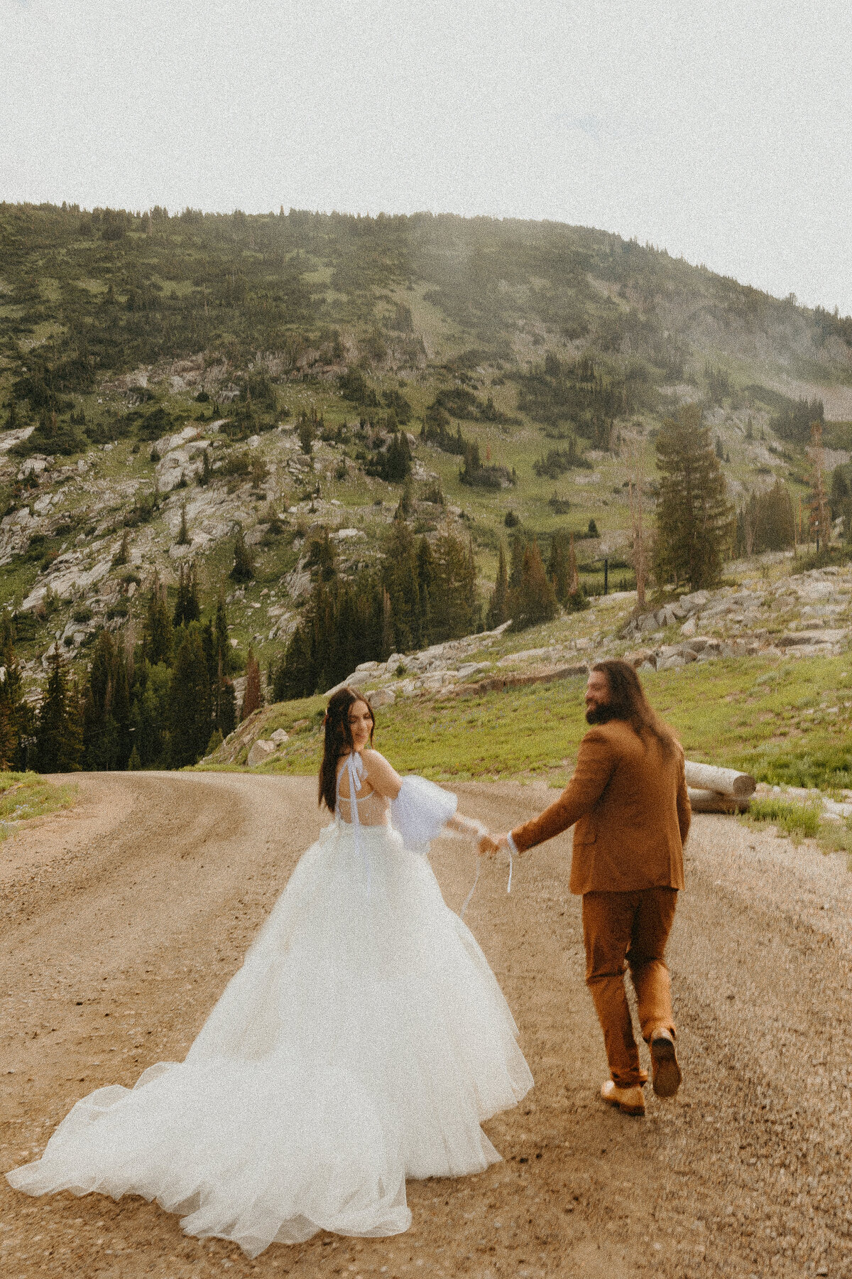 Bride and Groom Running on Dirt Road in Utah Albion Basin