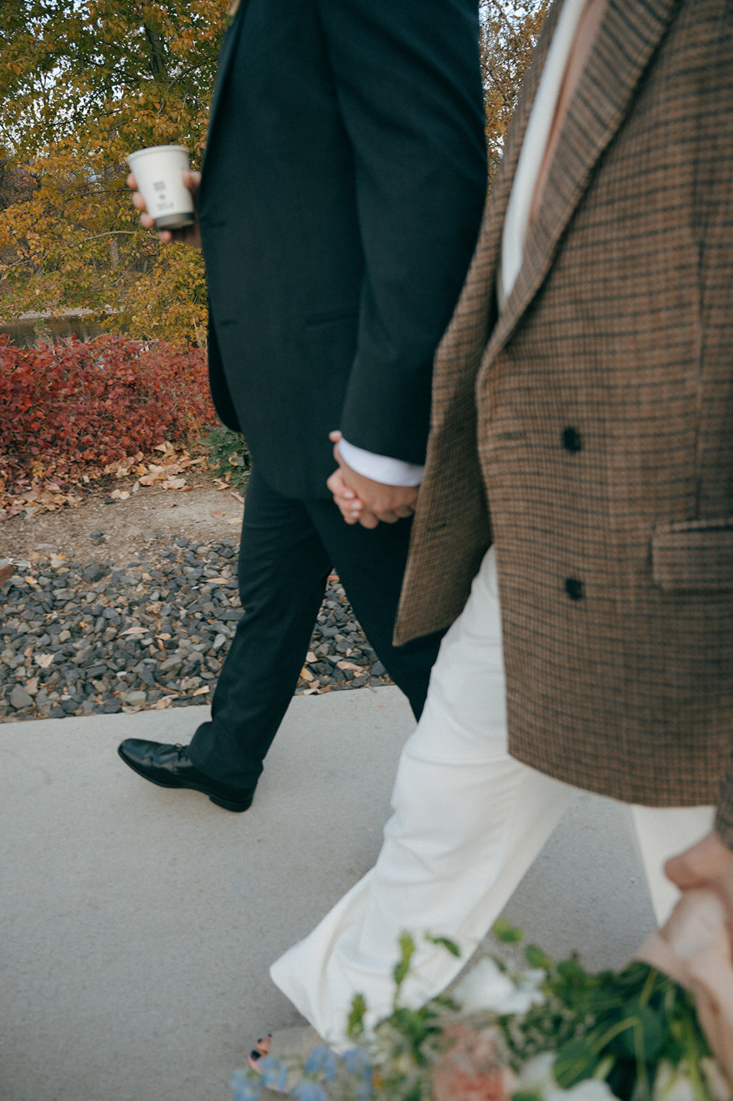  A close up of a couple's hands intertwined as they walk to their vow renewal.