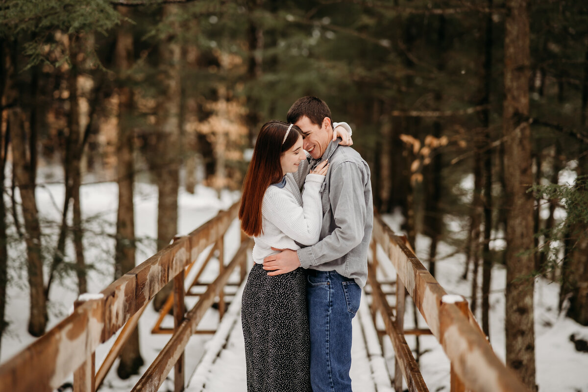 A romantic couple's photo set against Vermont's snowy landscape, capturing the warmth amidst the cold.