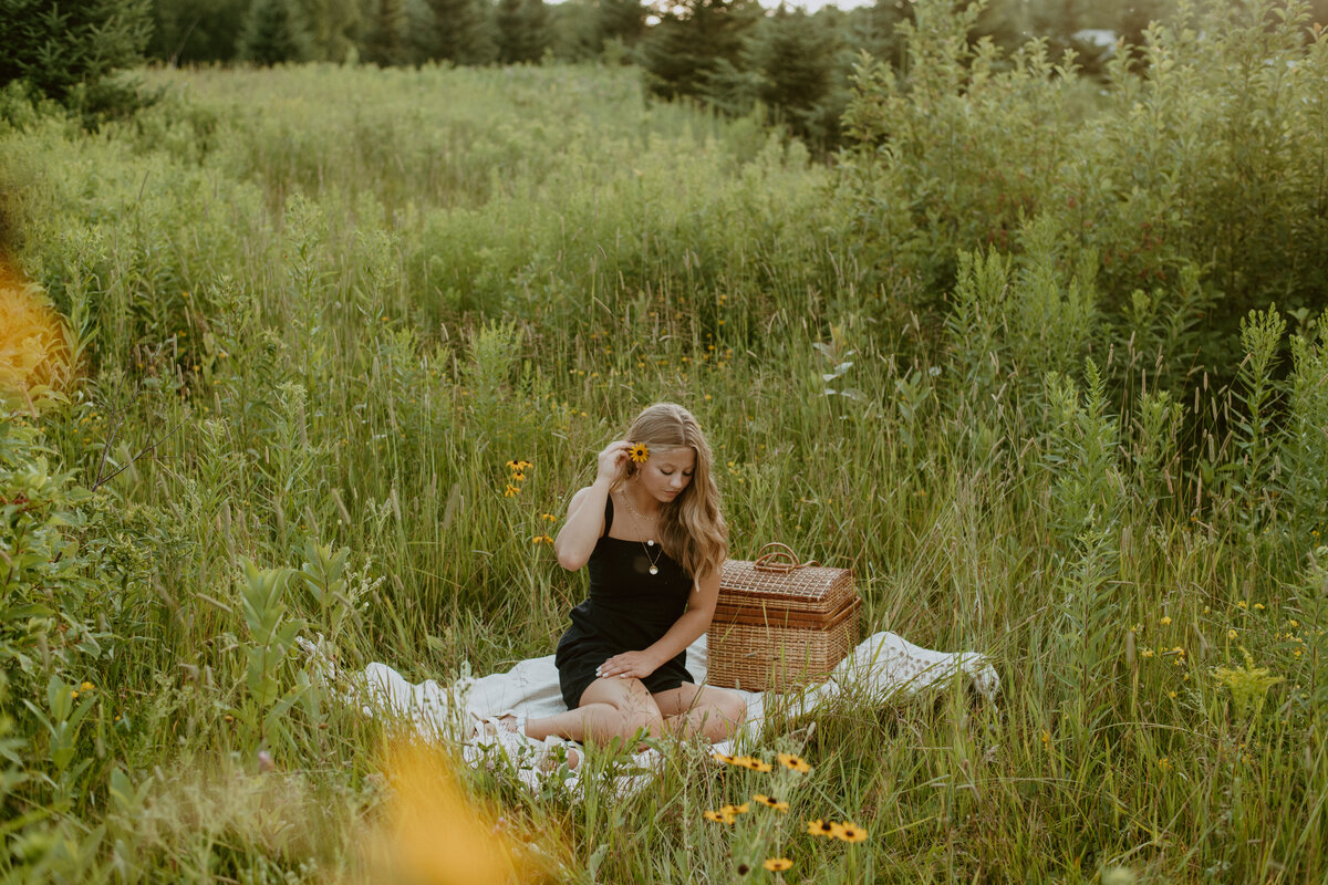 girl sitting on picnic blanket looking down