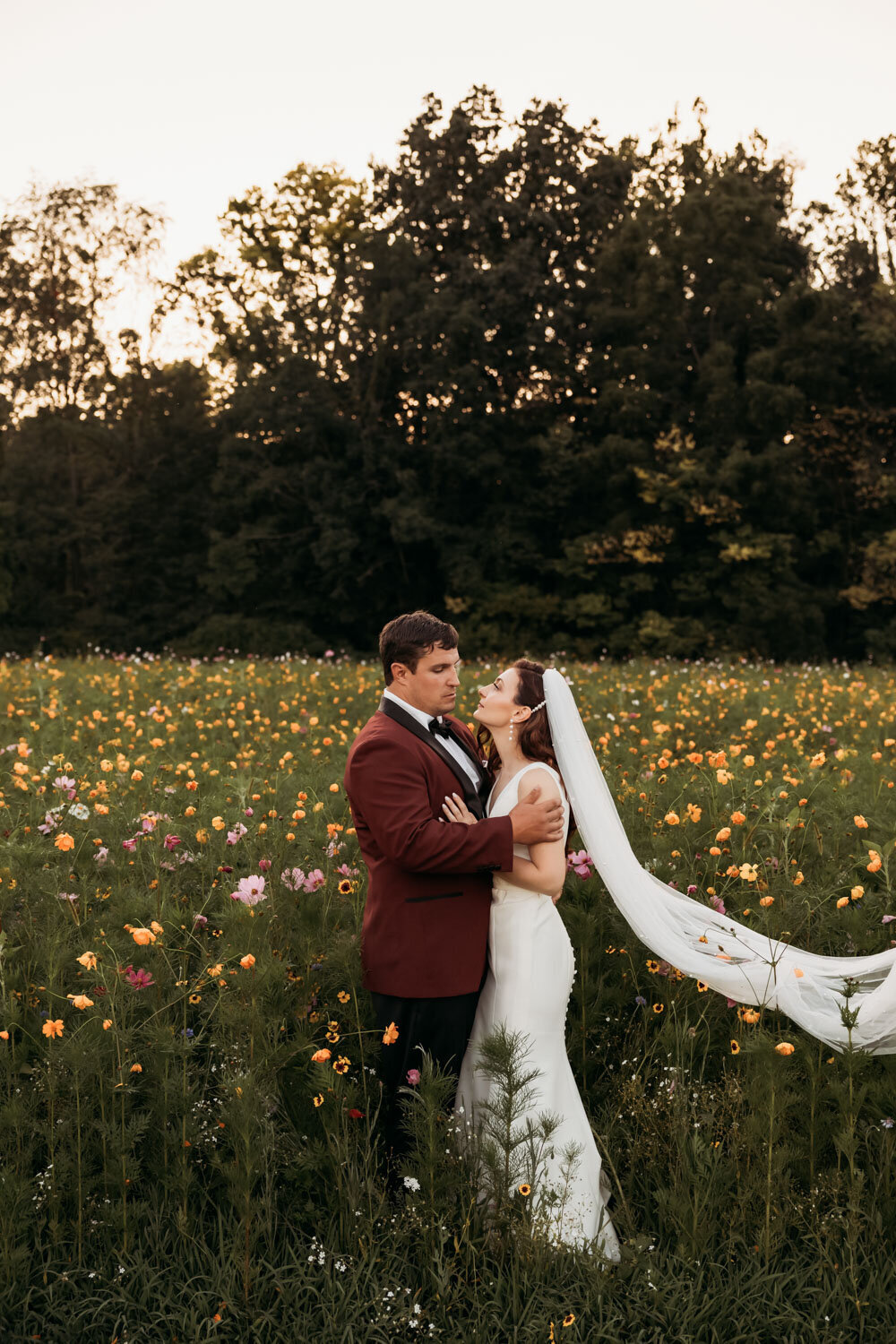 Bride and groom embracing in wildflower meadow