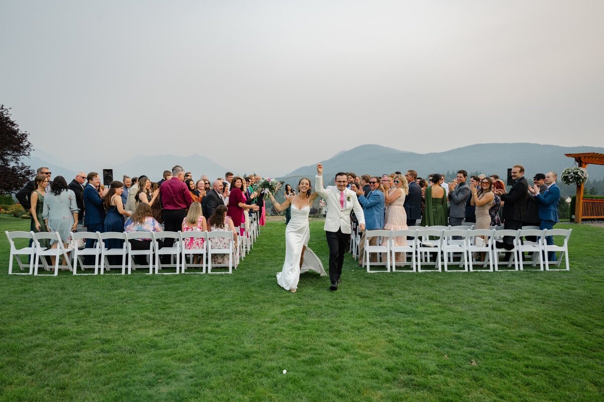 just married bride and groom holding hand in aisle at snoqualmie ridge wedding venue