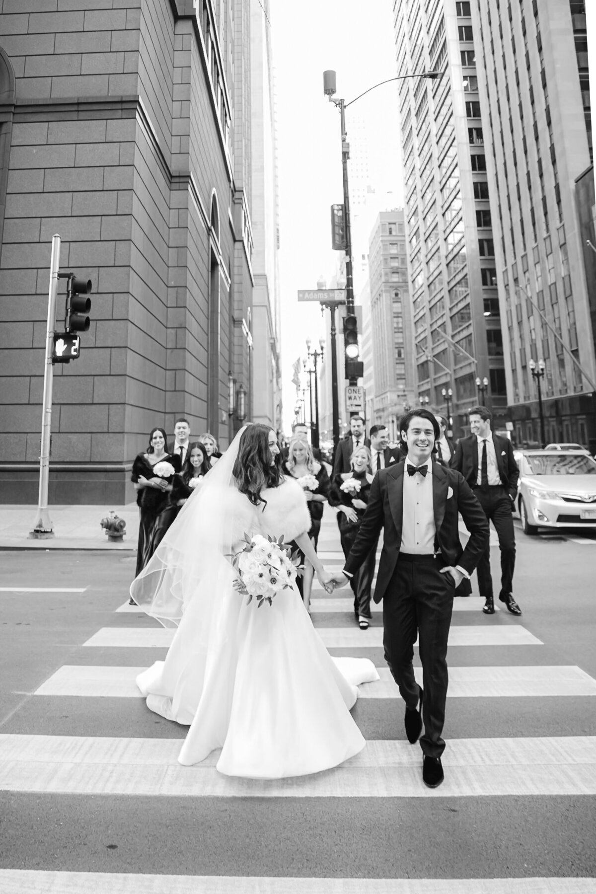 bridal party walking across Lasalle street in downtown chicago