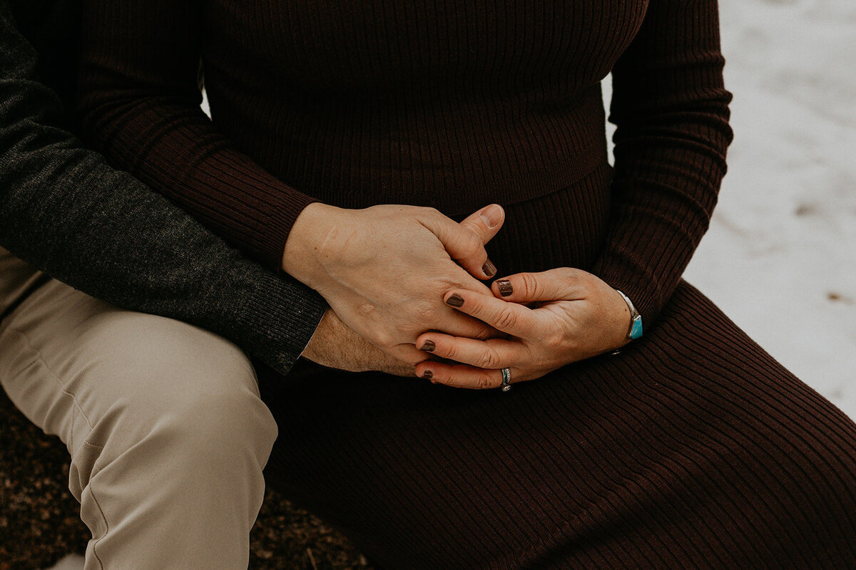 couple sitting together holding her pregnant belly