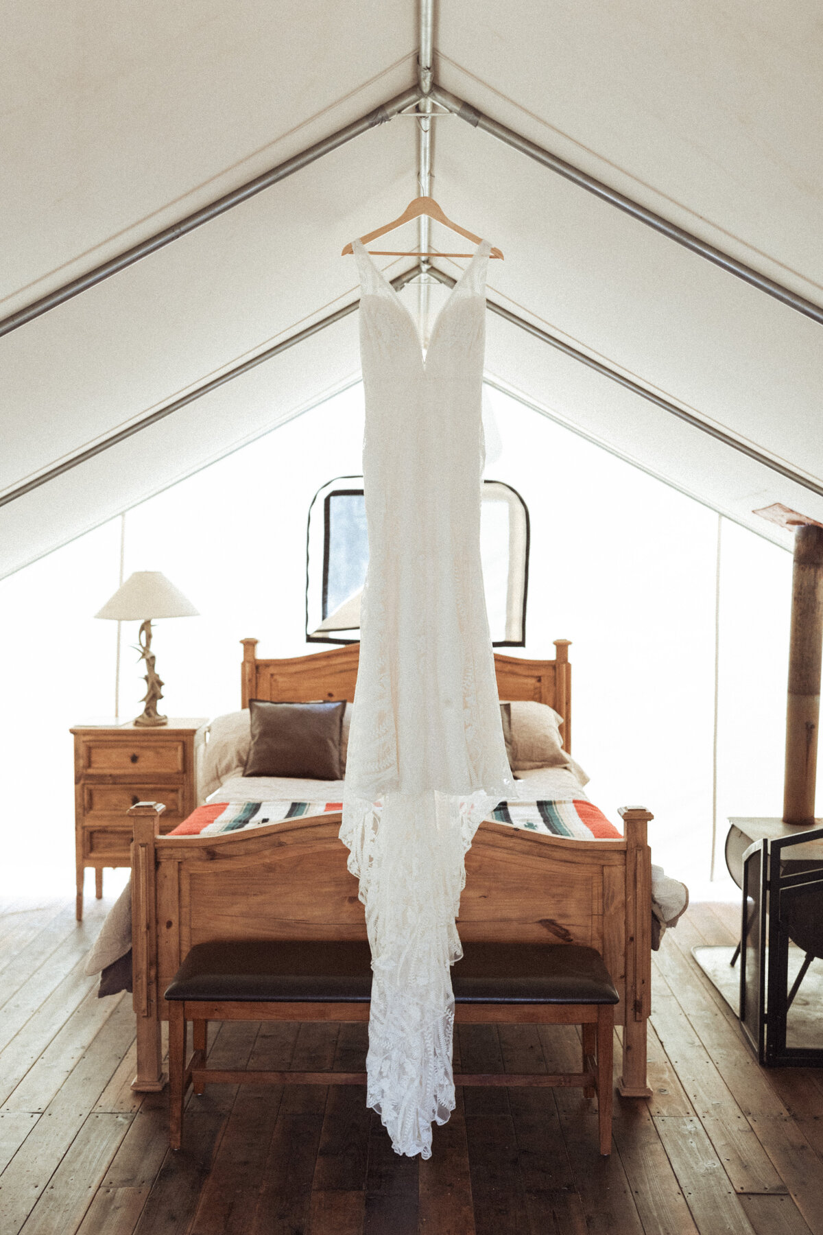 Bride's lace wedding dress hung up in her tent at Piney River Ranch in Vail, Colorado.