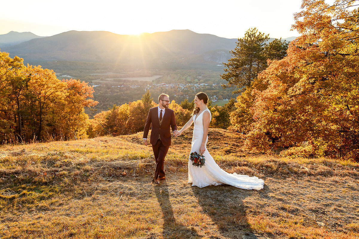 Groom leading bride on walk at Cranmore Mountain summit wedding
