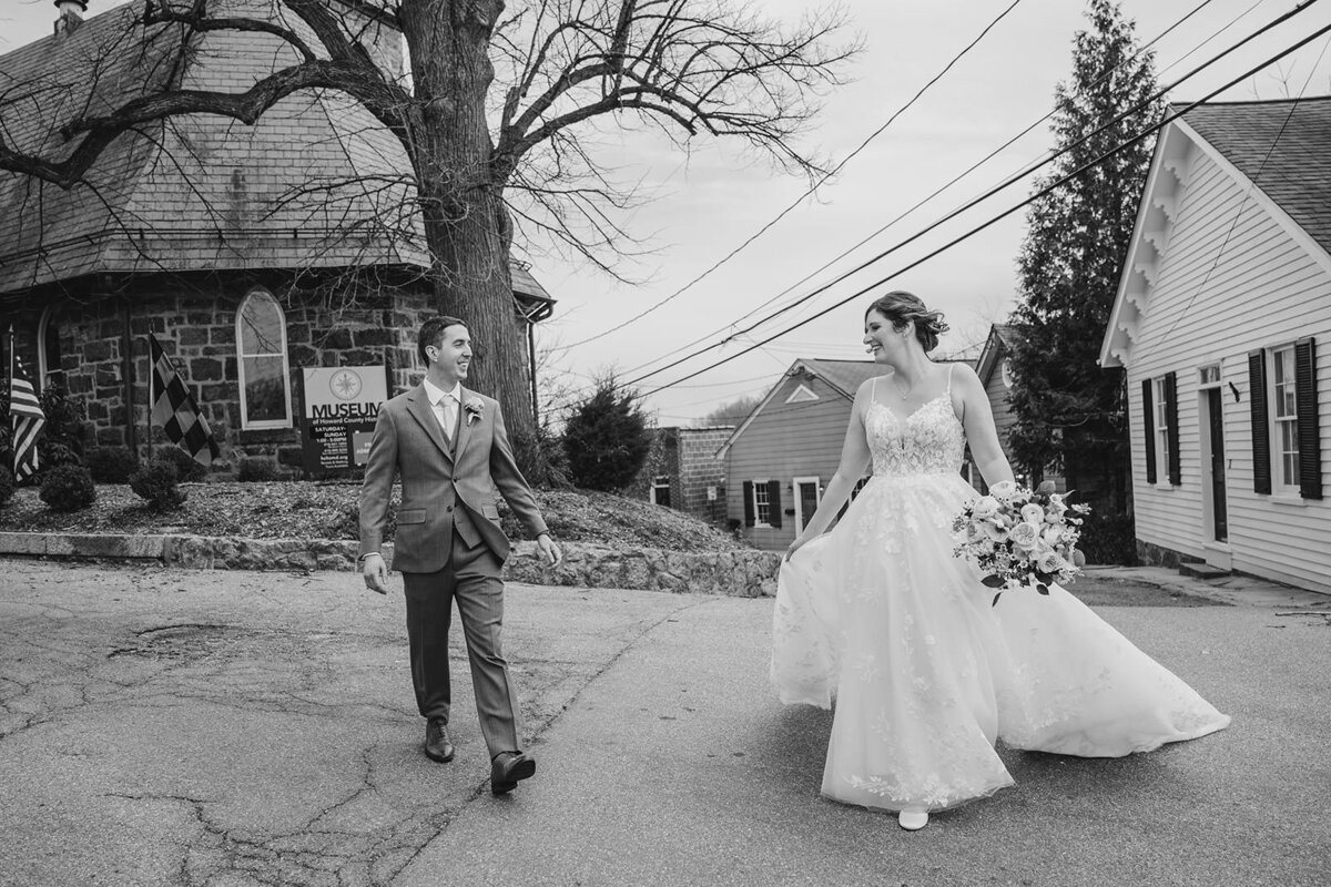 A wedding couple walking together across a road 