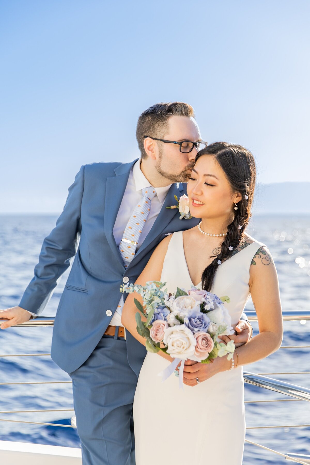 groom kissing bride in blue suit
